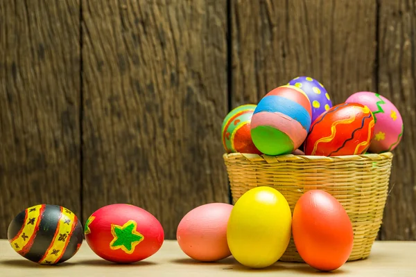 Uova di Pasqua in cestino e fondo legno — Foto Stock