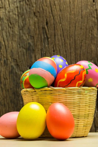 Uova di Pasqua in cestino e fondo legno — Foto Stock