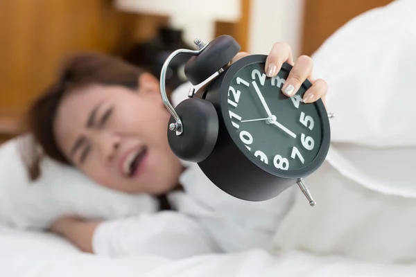 Mujer asiática durmiendo en la cama con alarma despertador en la mañana —  Fotos de Stock