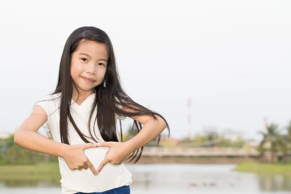 Joven chica asiática haciendo corazón con las manos — Foto de Stock