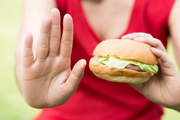 Жінка робить знак зупинки з гамбургером — стокове фото