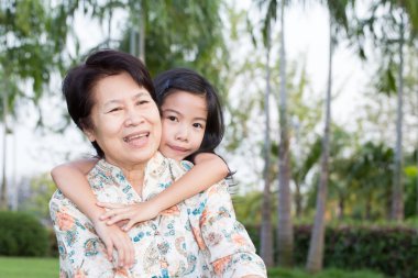 Büyükanne ve torunu parkta sarılma