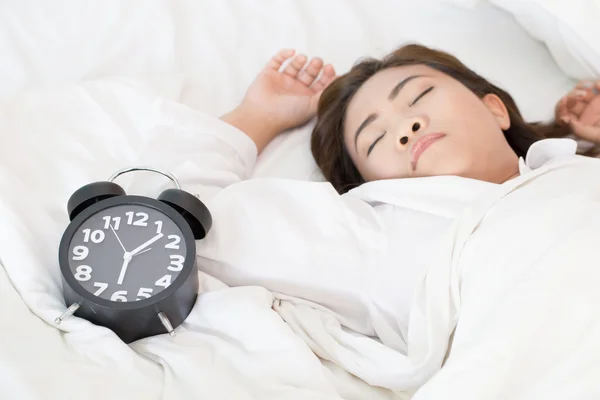 Asian woman sleeping on bed and wake up with alarm clock — Stock Photo, Image