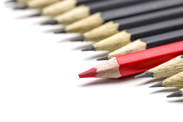 One red pencil among many black pencil