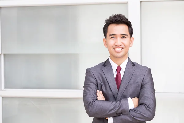 Asiatico uomo d'affari in piedi braccia incrociate e sorridente — Foto Stock