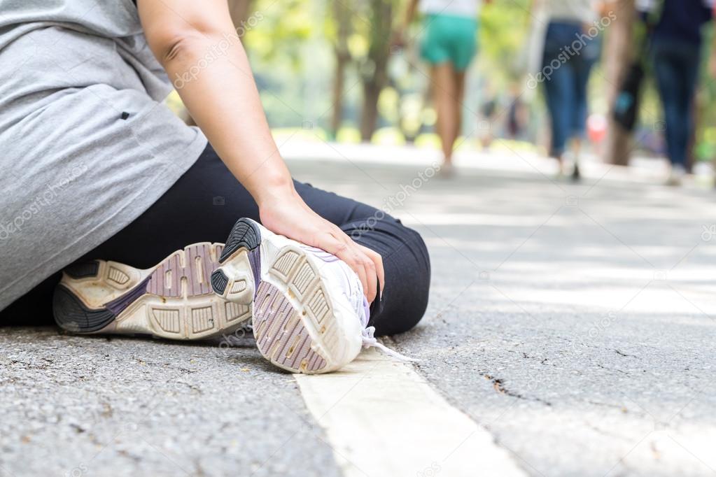 Sports injury. Woman with pain in ankle while jogging