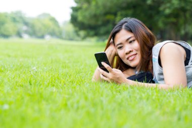 Asyalı kadın parkta Smartphone kullanarak