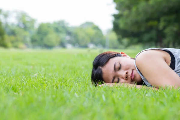 Mujer asiática durmiendo en la hierba en el parque —  Fotos de Stock