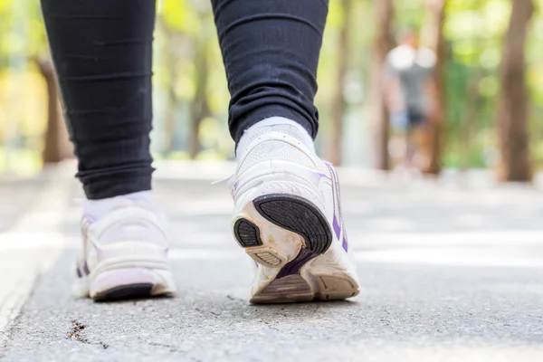 Closeup běžecké boty ženy, běhání v parku — Stock fotografie