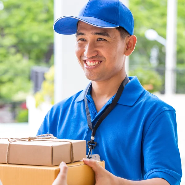 Entrega hombre sosteniendo una caja de paquete —  Fotos de Stock