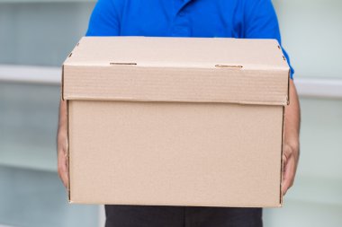 Bir parsel kutusu tutarak teslimatçı