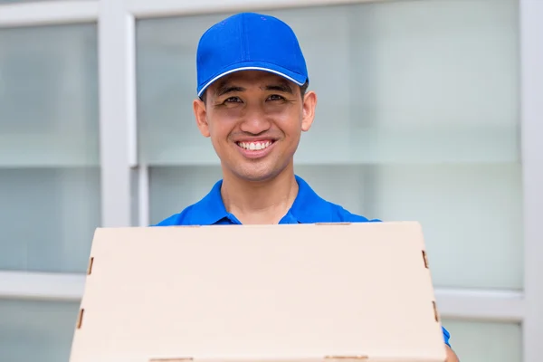 Entrega homem segurando uma caixa de pacote — Fotografia de Stock