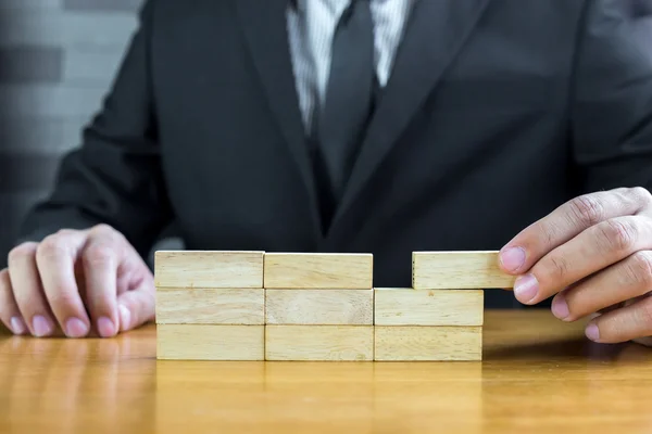 Businessman make a building with wood blocks — Stock Photo, Image