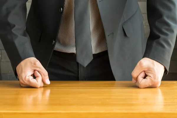 Businessman with clenched fist on the desk at office — Stock Photo, Image