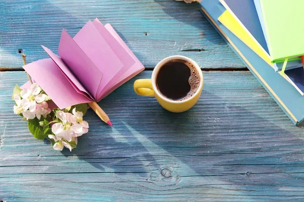 Open blank notebook and pencil, cup of coffee,  flowers on wooden table, spring, concept of home comfort, romantic reading