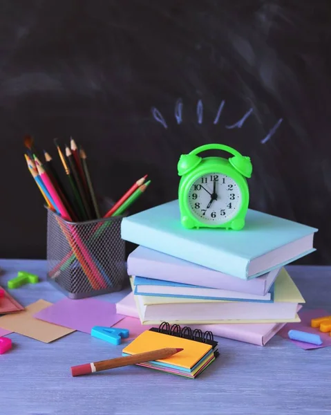 Back to school, stack of books, clock, stationery on the table