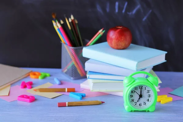 Back to school, stack of books, clock, stationery on the table