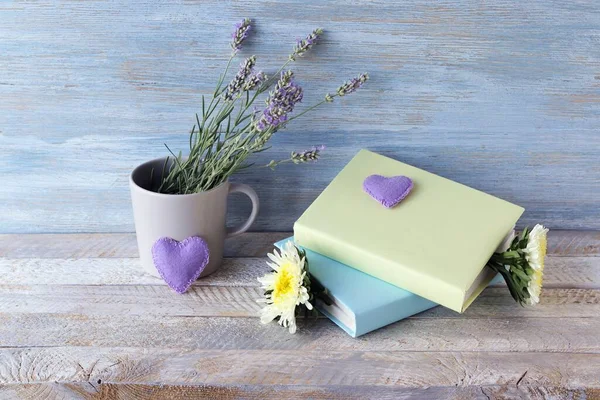 Stack of books, flowers, lavender bouquet, hearts on a wooden table, romantic concept, education, back to school