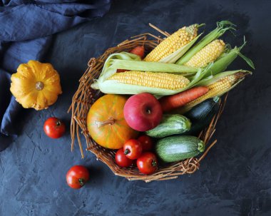 Bir sepetin içinde taze taze sebzeler, beton bir masa, organik doğal ürünler, sağlıklı yiyecekler, ev yemeği.
