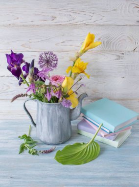 Çiçekli, kitaplarla ve kırsal cazibeyle sakin bir hayat bahar çiçekleri ve katlanmış kitaplarla sakin bir hayat.