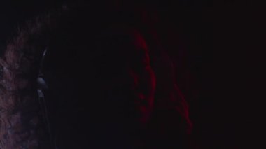 Happy woman listens audio music using modern headphones in colorful neon light
