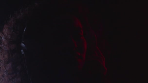 Glückliche Frau hört Audio-Musik mit modernen Kopfhörern in buntem Neonlicht — Stockvideo