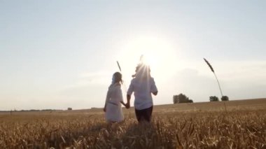Üç kişilik mutlu aile el ele tutuşup doğa alanında rahatlıyor.