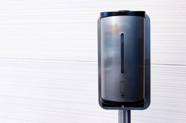 El dezenfektanı. Covid 19. periyotta beyaz bir duvarın yanında el dezenfektanı..