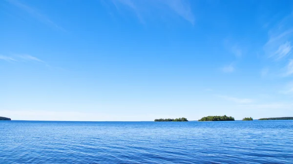 Gröna öar i blått vatten och himmel — Stockfoto
