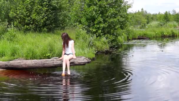 Girl on lake log relaxing — Stock Video