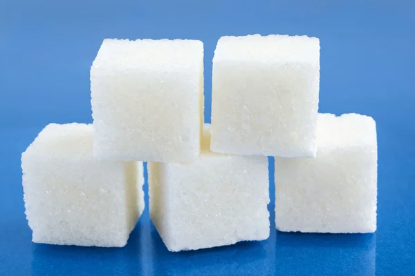 Sugar cubes on blue — Stock Photo, Image
