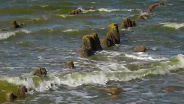 Golven die breken op oude pier — Stockvideo