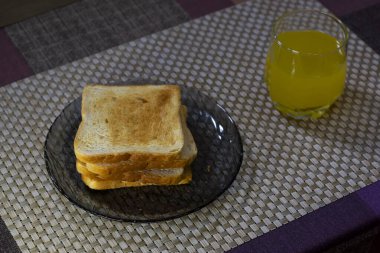 Kahvaltı için kızarmış ekmek ve bir bardak portakal suyu.