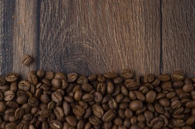 Ahşap bir masada kavrulmuş kahve çekirdekleri.