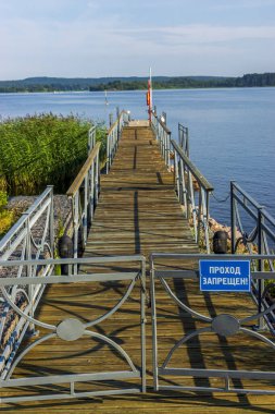 Yaz gölünde tahta iskele kapısında giriş işareti yok.