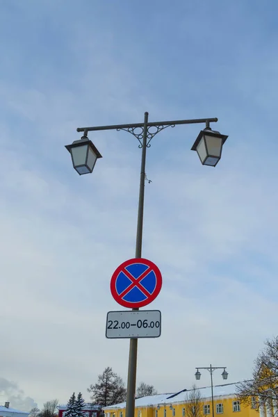 Ornate poles with street lamps and sign prohibiting parking and stopping cars