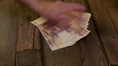 Erkek eller nakit parayı döndürür ve teslim eder.