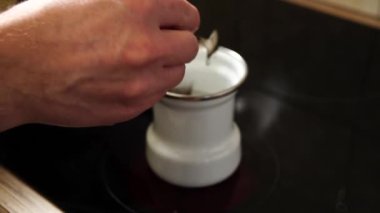 İki kaşık doğal kahveyi kahve makinesine döker.