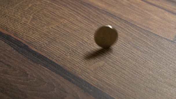 Zeitlupe Dreht Sich Eine Einzige Münze Auf Einem Holztisch — Stockvideo