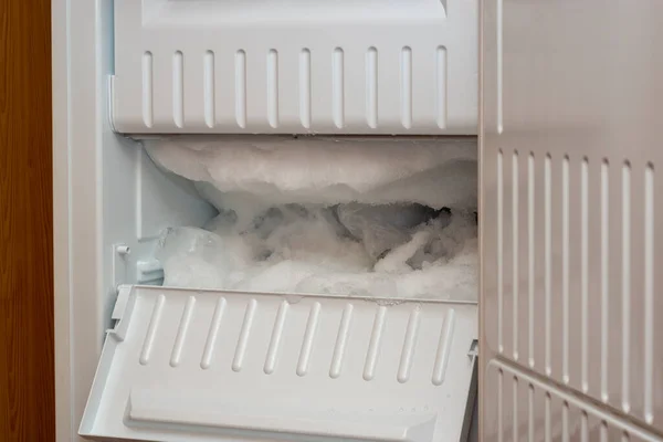 Fridge freezer is covered with an ice and snow