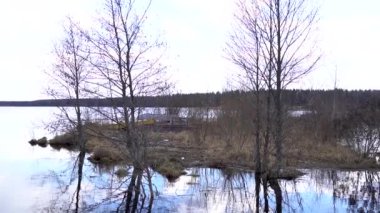 Yavaş çekimde eğil, sakin bir manzara ve taşan göl kıyısında tekneler.