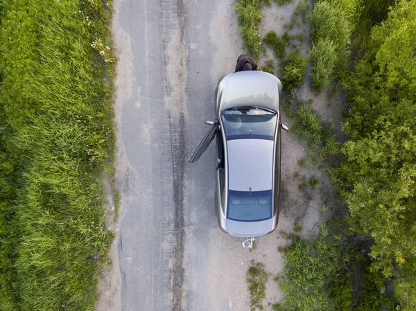 Photo aérienne de l'homme répare la voiture sur le côté de la route de campagne le jour d'été — Photo