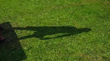 Çimlerin üzerindeki pinpon oyuncusunun gölgesi gerçek zamanlı tenis oynar