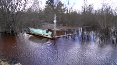 Rusya 'da baharda kıyıdaki yavaş çekim göl ve köy teknesi manzarası sular altında kaldı.