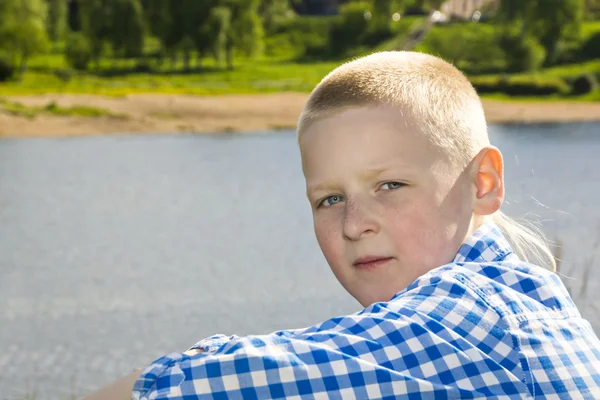 Portrait of boy on summer river background — Stockfoto