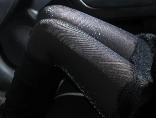 Slender sexy legs in shiny pantyhose in car — Stock Photo, Image