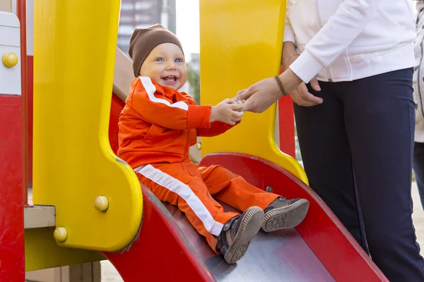 Kid with a smile on children's slide — Stock Photo, Image