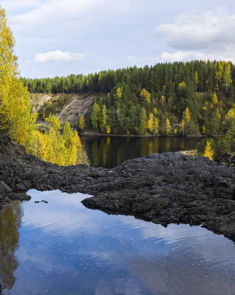 A rock az őszi erdőben vadon élő tó — Stock Fotó