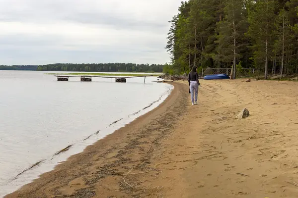 Fille va sur la côte du lac dans la taïga — Photo