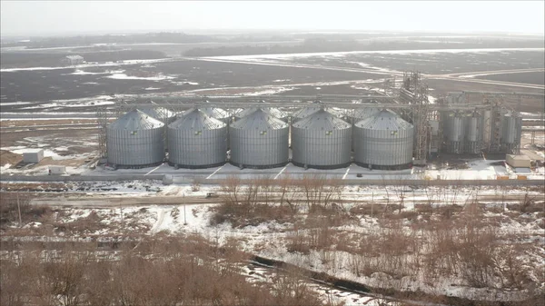 Grain storage elevator. Evening winter landscape. Industrial elevator on the background of a winter field.